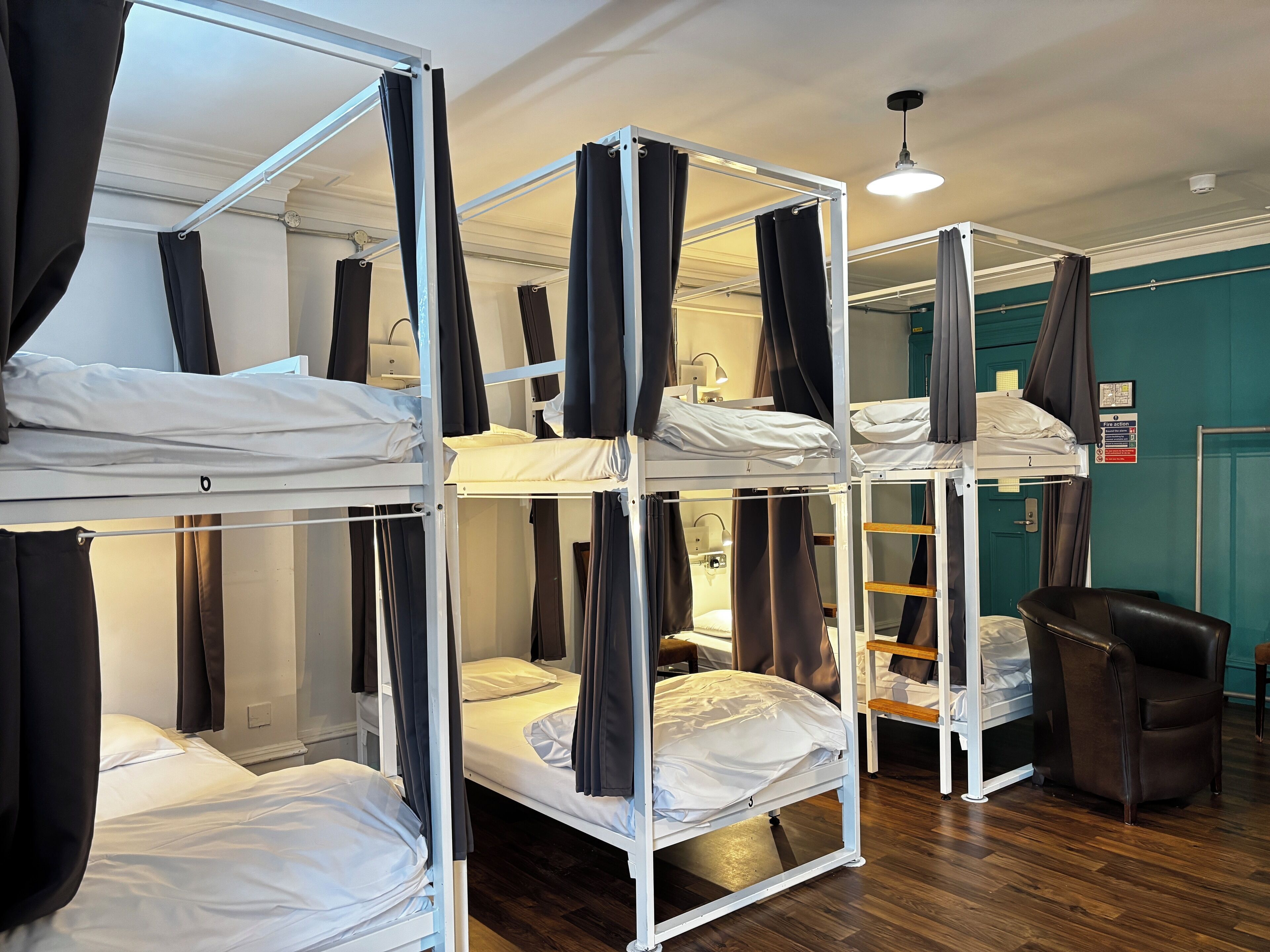 Une chambre avec des lits superposés, un bureau et une chaise.