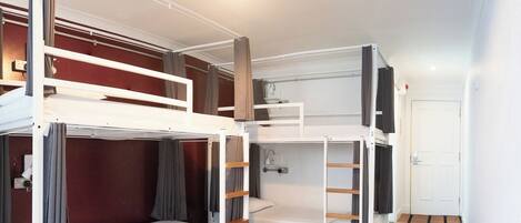 A room with bunk beds, a white door, and a tiled floor.