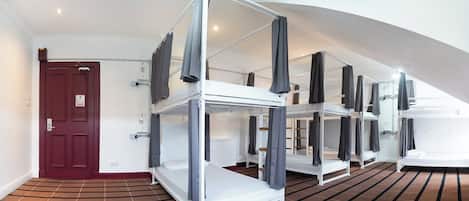 A room with bunk beds, a red door, and a striped carpet.