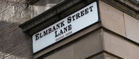 A street sign for 'ELMBANK STREET LANE' with 'CHARING CROSS' below it.