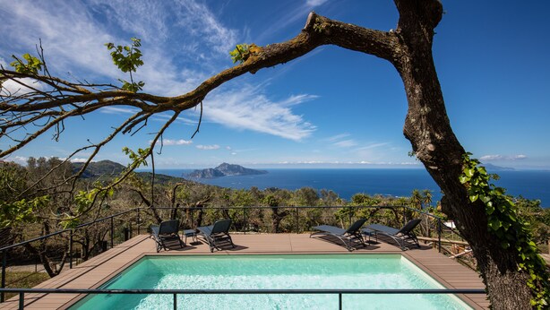A pool area with lounge chairs and a view of the sea. - Casa Aprea (Massa Lubrense)