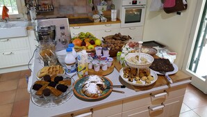 Un plan de travail de cuisine sur lequel on trouve divers aliments, notamment des fruits, des noix, des biscuits et des produits laitiers.