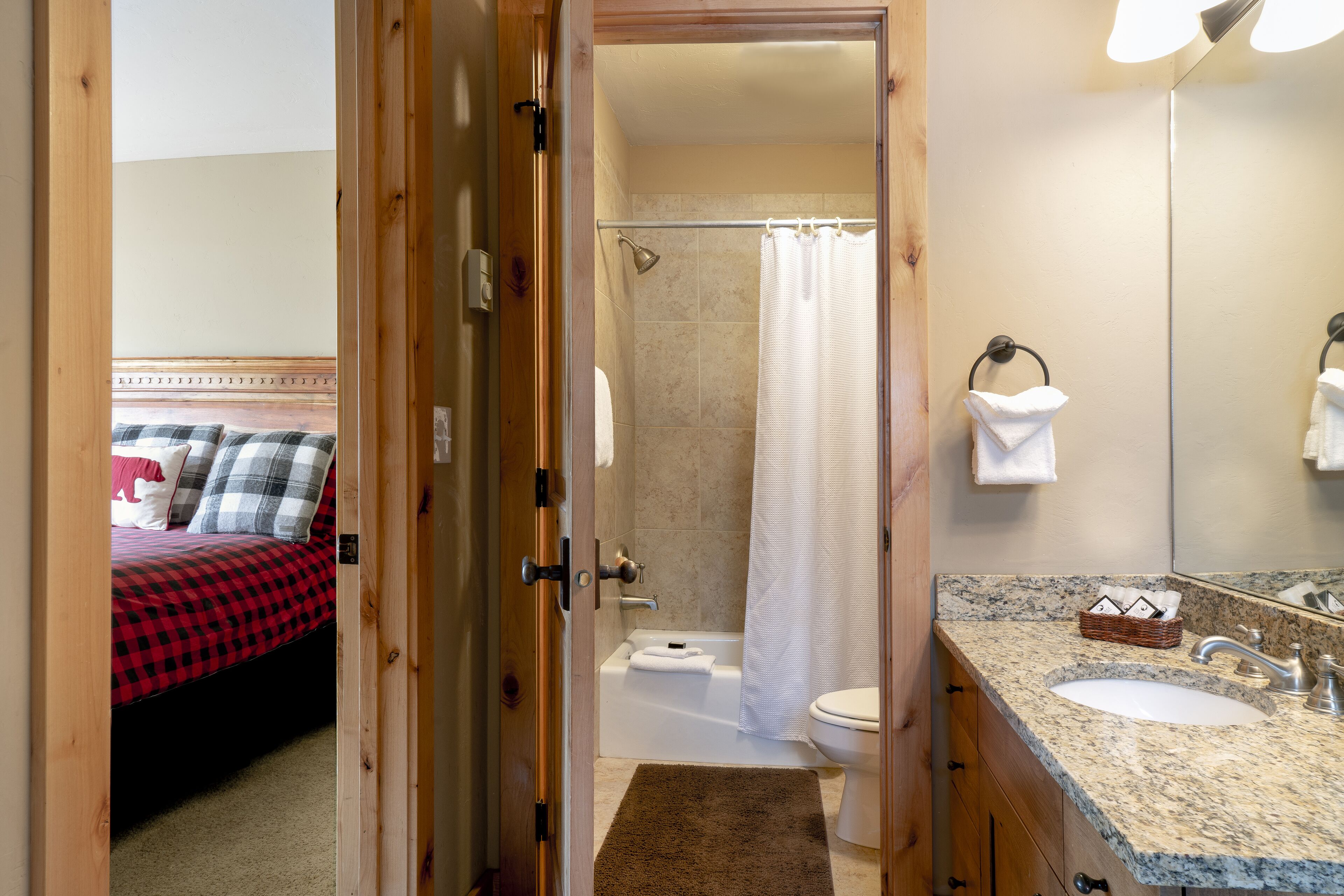 A hotel bathroom with a shower, toilet, and sink.