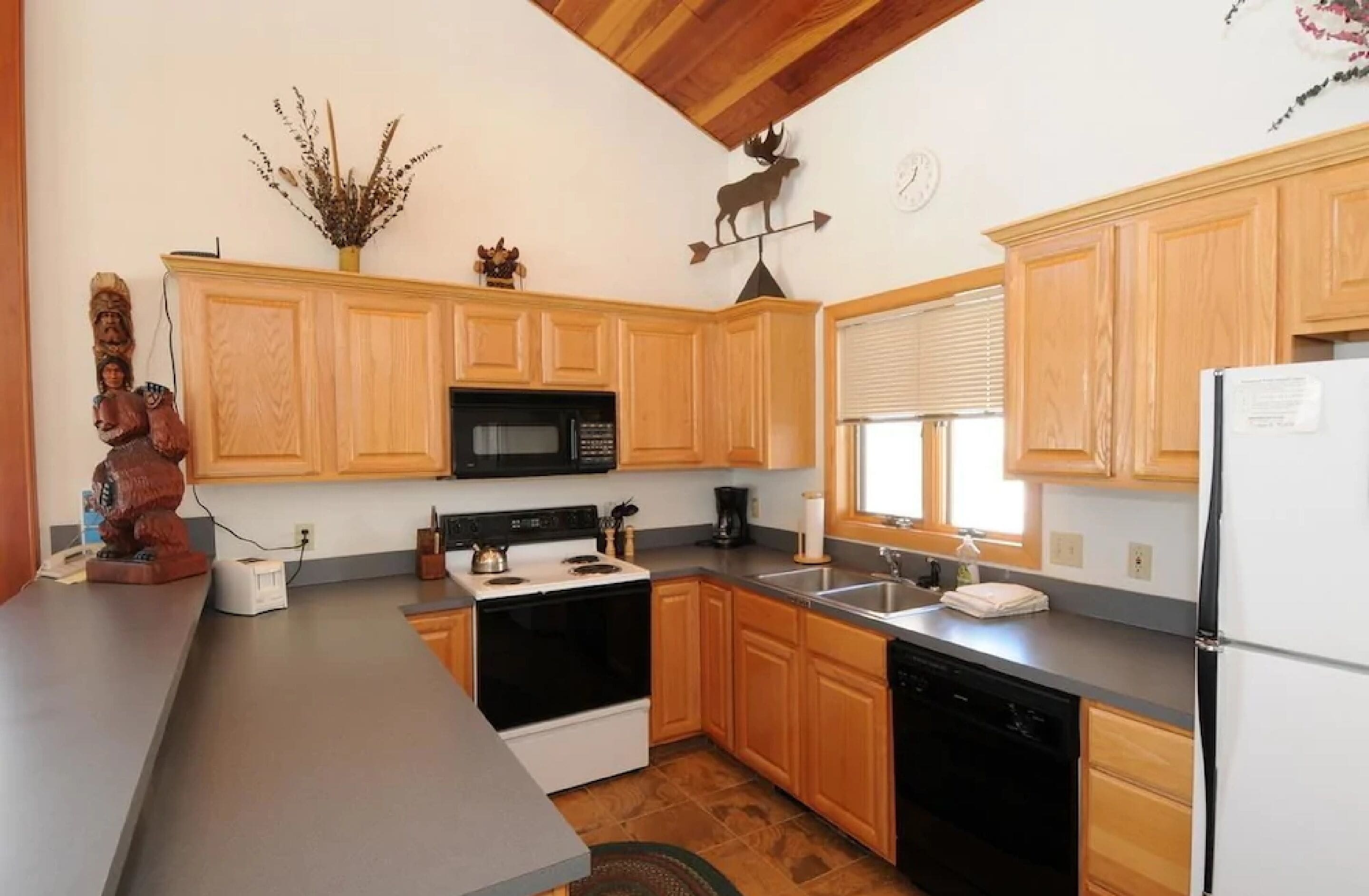 A kitchen with wooden cabinets, a microwave, stove, and dishwasher.