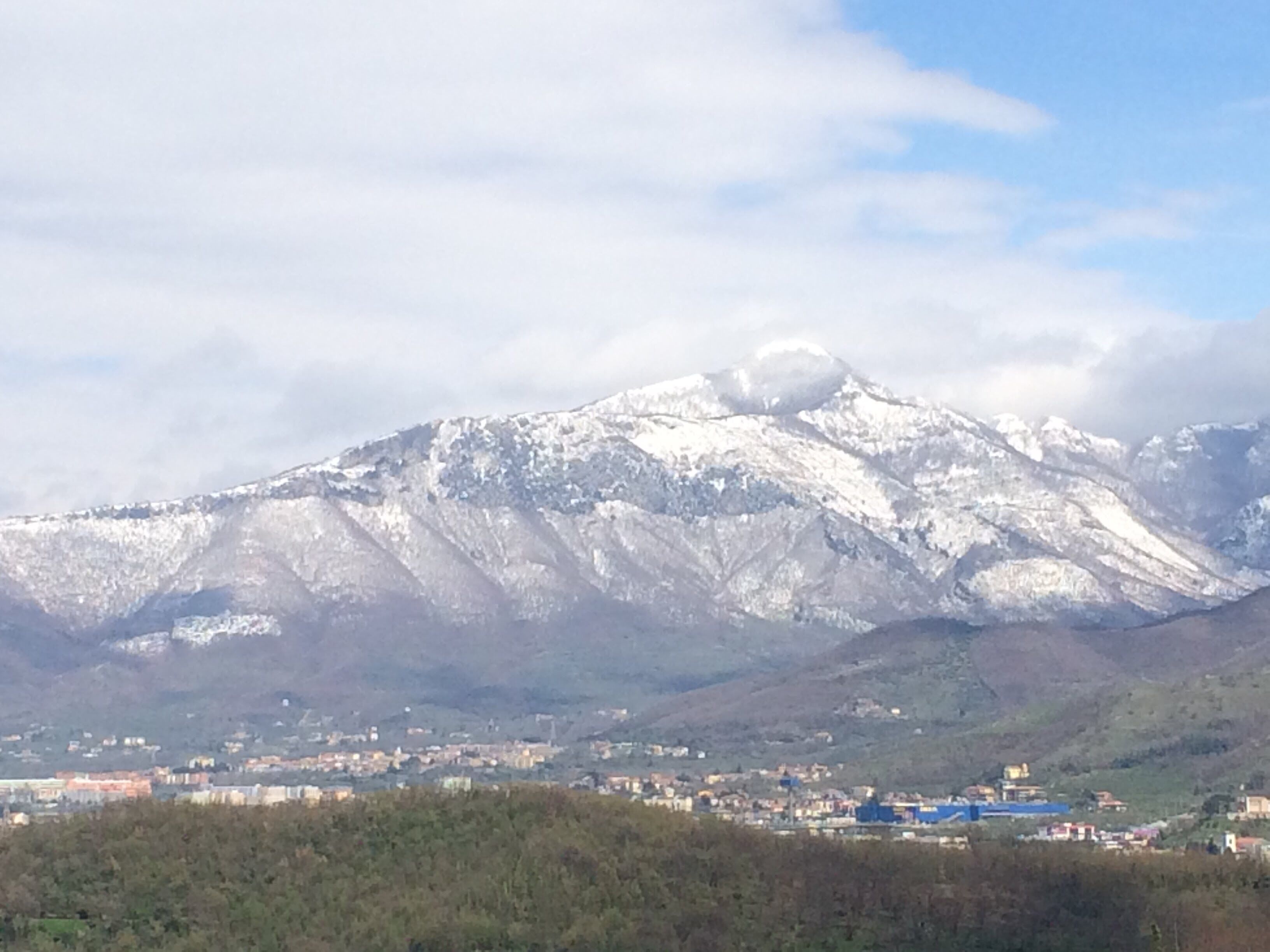 A snow-covered mountain with a town in the valley below.