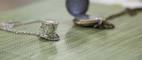 Un collar con un dije y una moneda sobre una superficie de tela verde.