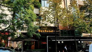 A modern building with a unique architectural design, featuring a mix of glass and metal elements. - Nov Hotel (Tirana)