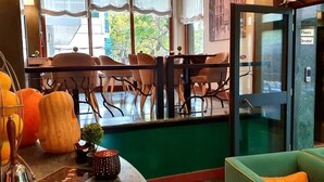 A restaurant with a pool table, chairs, and a green sofa. - Nov Hotel (Tirana)