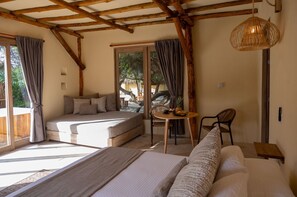 A cozy bedroom with a bed, a small table with fruit, and a view of the outdoors.