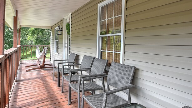 A covered porch with wicker chairs and a hammock.