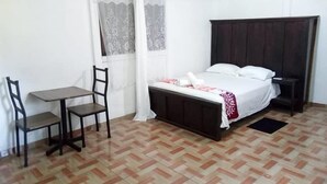 Een kamer met een bed, een bureau en een stoel.