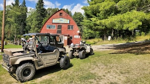 A rustic red barn with a sign reading "Deer Lake Charlie's". - Cabin on lake close to ATV & snowmobile trails (Bigfork)