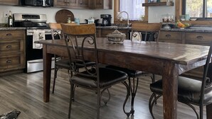 A kitchen with wooden cabinets, a dining table, and a chandelier.