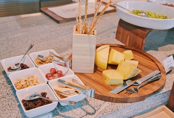 A buffet setup with various food items and utensils. - Grand Hyatt Hefei (Hefei)