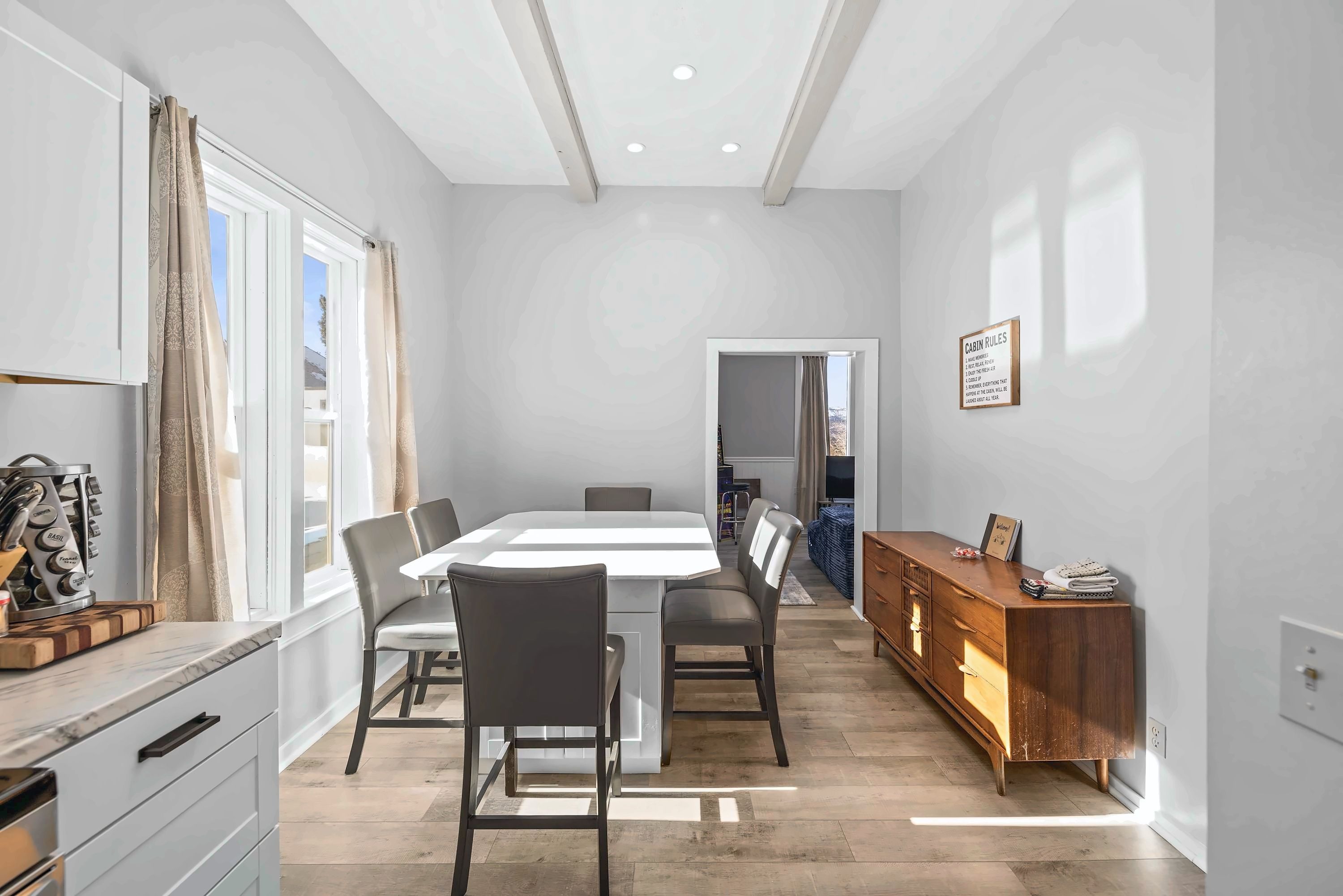 【Dining Room】 Original exposed beams overhead — the sideboard behind you is stocked for the group.