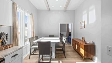 【Dining Room】 Original exposed beams overhead — the sideboard behind you is stocked for the group.
