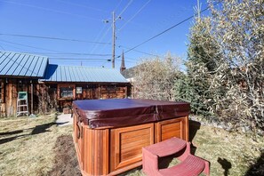 A wooden cabin with a hot tub and a small table. - Forest Fortress at the Cloud City Castle & Hot Tub (Leadville)