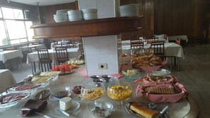 A buffet setup with various food items and dishes.