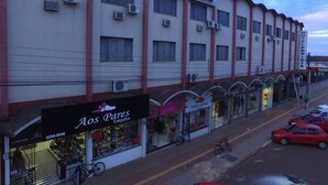 Ein Hotel mit mehreren Zimmern, ein Laden mit Schuhschaufenster und einige geparkte Autos.