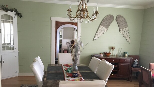 A dining area with a long table, chairs, a chandelier, and decorative items. - Romantic Slipper Tub (Carmine)