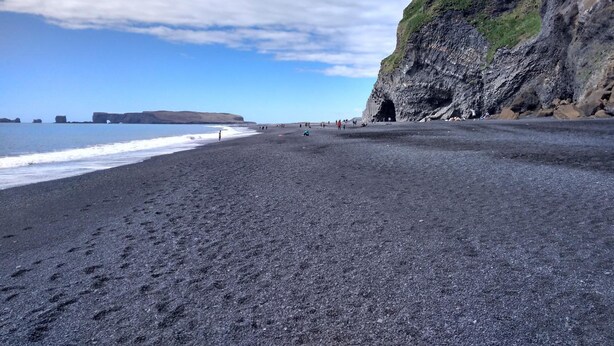 A beach with a rocky cliff and a clear sky. - Ársalir Guesthouse (Vik I Myrdal)
