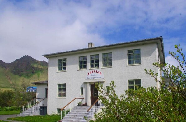 A white building with a sign reading "Amsalin Bed and breakfast" and a staircase leading to the entrance.