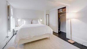 A modern bedroom with a large bed, bedside tables, a wardrobe, and a floor lamp. - Fabulous Classic Victorian Home in Pacific Heights (San Francisco)