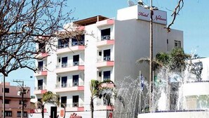 A hotel with multiple floors, balconies, and a fountain. - Hotel Nolasco (Macaé)