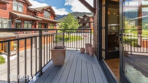 A wooden cabin with a balcony overlooking a mountain landscape. - Charming Big Sky Condo! Cozy Fireplace, 10 Min Drive to Resort, 3 Min drive to T (Big Sky)