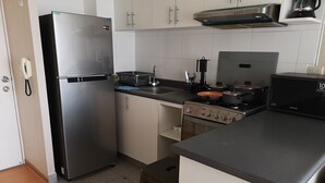 A compact kitchen with a refrigerator, stove, and sink. - LIMA FLAT 8 1D BETWEEN AIRPORT AND MIRAFLORES (Cercado de Lima)
