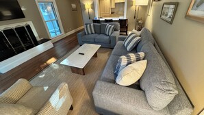 A living room with a gray sofa, a striped armchair, a coffee table, and a fireplace.