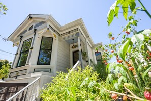 Stunning two-story house with a gabled roof and bay window, surrounded by lush greenery.