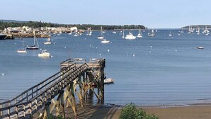 A pier extending into calm waters with numerous boats anchored nearby. - Best views on MDI - 2 bedroom 2 bath condo - waterfront with in ground pool (Southwest Harbor)