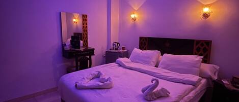 A modern bedroom with a large bed, two wall-mounted lights, and a ceiling light.