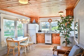 Enjoy meals in this kitchen with a central island, refrigerator, stove, and sink, and dine at the table for four.