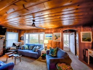 Relax in this inviting living room with two sofas, a side table, and a mounted TV.