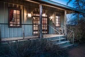 Un chalet rustique doté d’une véranda, d’un escalier en bois et d’une balustrade.