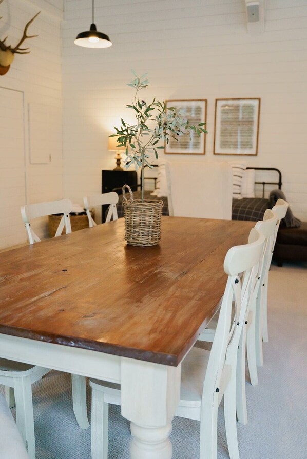 A dining table with white chairs, a woven basket, and a hanging light fixture. - Modern Farmhouse in Wine Country. (Dayton)