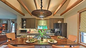 Una cocina moderna con una isla central, electrodomésticos de acero inoxidable y una lámpara decorativa en el techo.