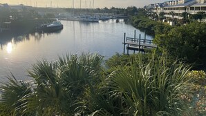 Un puerto deportivo con barcos amarrados, un muelle de madera y una hilera de casas con balcones.