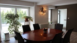 Une salle à manger moderne avec une table ronde, des chaises noires et une plante en pot.