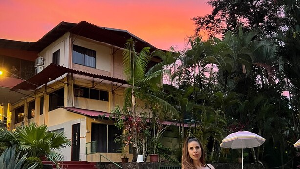 A swimming pool with a person in a black swimsuit standing by the poolside. - Divisamar Manuel Antonio, A natural paradise for you. (Quepos)