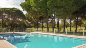 Une piscine rectangulaire entourée d’une terrasse en bois.