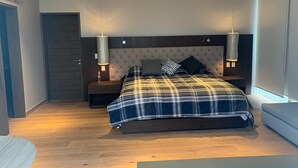 A modern bedroom with a large bed, two bedside tables, and a built-in headboard. - PH CIELO ALAMEDA, JUAREZ 52 (Centro)