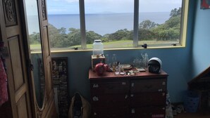 A room with a large window overlooking a scenic view. - Looking out over the ocean with uninterrupted views to Mayor Island and beyond! (Onemana)