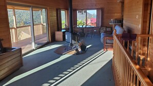 A wooden cabin interior with a dining area, kitchen, and a balcony with a mountain view. - Enjoy the spectacular views from the balcony and cabin at this mountain location (Julian)