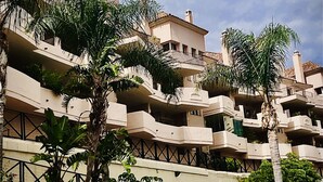 A multi-story hotel with balconies, a swimming pool, and lush greenery. - Sun-Soaked Penthouse w/ 3 Terraces • Walk to Beach, Port & Dining • Sleeps 6 (Manilva)