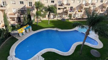 Een buitenzwembad, een verwarmd zwembad, ligstoelen bij het zwembad