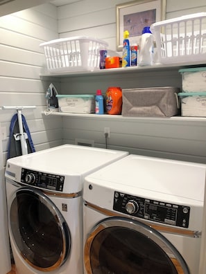 Convenient laundry facilities with two washing machines and a drying rack.