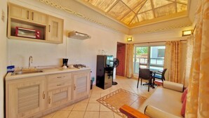 Un espacio habitable compacto con kitchenette, comedor y sofá.